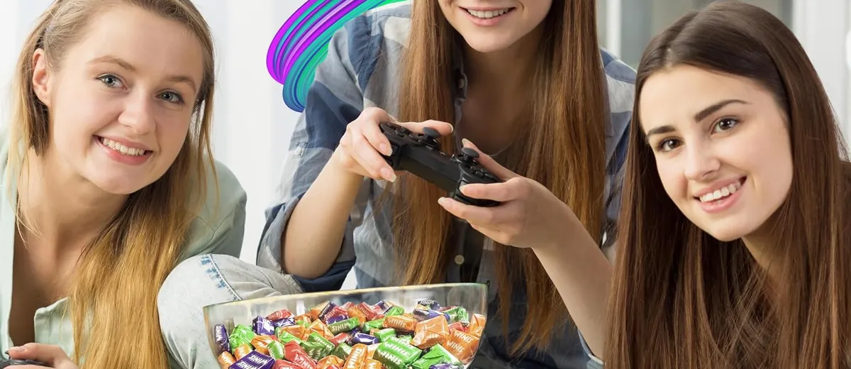 Three friends playing a video game with a bowl of wrapped Winis chews between them