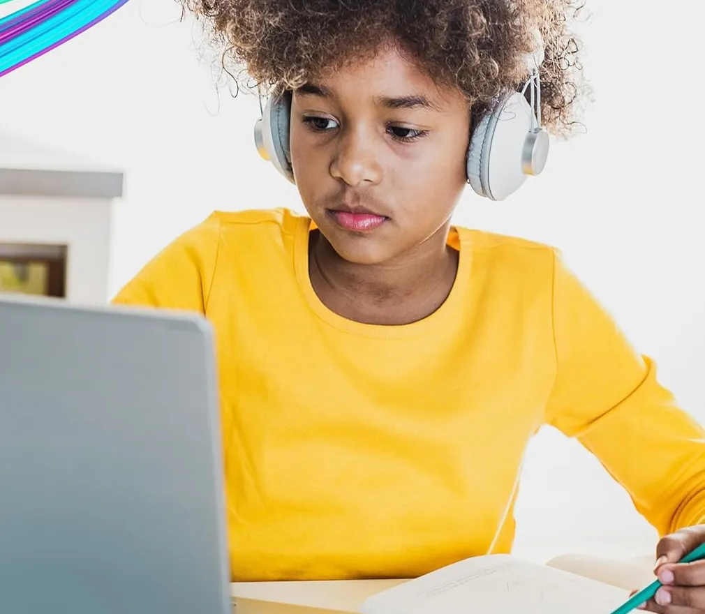 A girl in headphones doing homework at her laptop